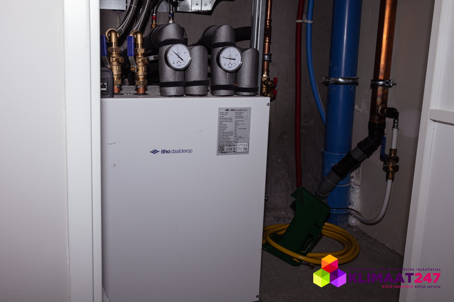 Itho Daalderop bodemwarmtepomp met leidingwerk en manometers in de technische ruimte