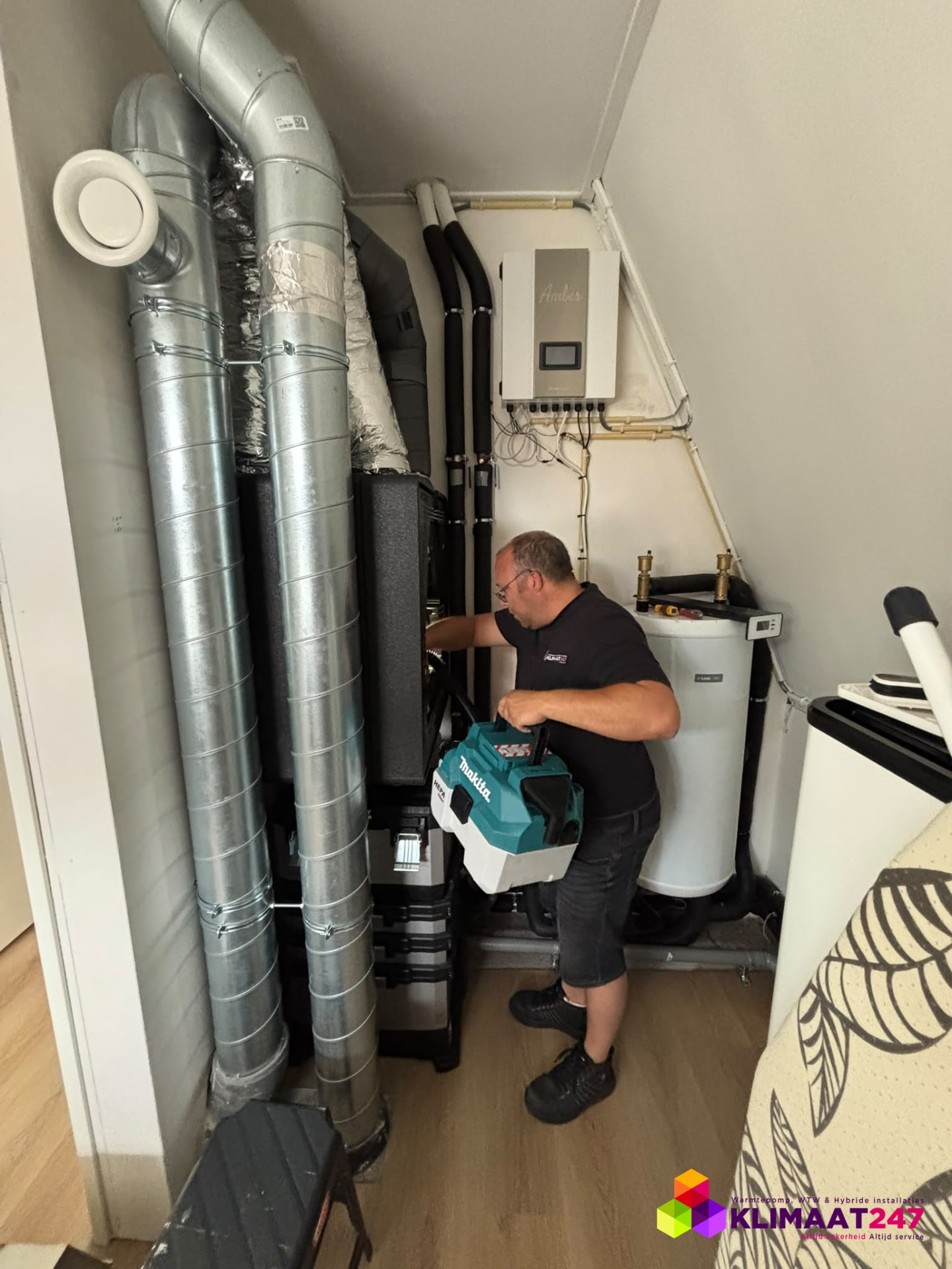 Monteur van Klimaat247 voert onderhoud uit aan de warmtepomp en WTW-unit